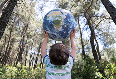 enfant qui porte une planète gonflable